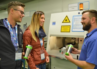 Mitarbeiter der NIDEC GPM GmbH zeigt Besuchern der Industrie InTouch ein gefertigtes Produkt
