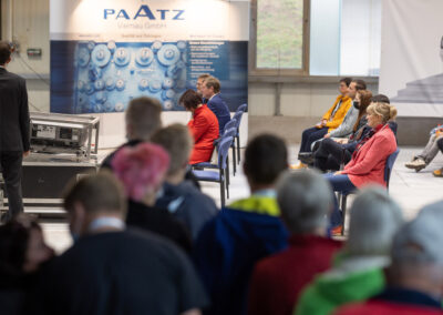 Eine Gruppe von Teilnehmenden der INDUSTRIE INTOUCH Thüringer Wald 2021 verfolgen eine Unternehmenspräsentation eines Mitarbeiters der Paatz Viernau GmbH