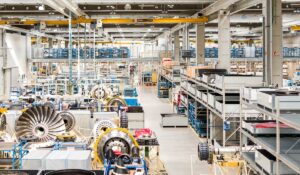 Einblick in eine große Fertigungs- und Lagerhalle voller Einzelteile und Regale der N3 Engine Overhaul Services GmbH & Co. KG, einem teilnehmenden Unternehmen bei der INDUSTRIE INTOUCH 2022.