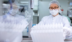 Ein Teammitglied entnimmt einem Förderband ein Produkt der Röchling Medical Solutions SE, einem teilnehmenden Unternehmen bei der INDUSTRIE INTOUCH 2022.