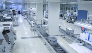 Zu sehen ist die Fertigungshalle mit Transportbändern und Teammitgliedern der Röchling Medical Solutions SE, einem teilnehmenden Unternehmen bei der INDUSTRIE INTOUCH 2022.
