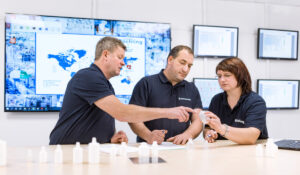 Drei Teammitglieder besprechen in einem Meetingraum ein Produkt der Röchling Medical Solutions SE, einem teilnehmenden Unternehmen bei der INDUSTRIE INTOUCH 2022.